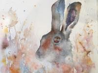 Staying low Brown hare peeping out of autumn foliage