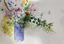 flowers overflowing a blue vase with eucalyptus leaves