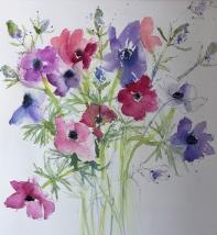 Pink and blue anemones against a white background with sea thistle