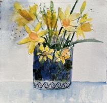 daffodils in a blue vase with pattern on bottom