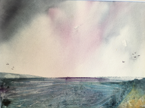 Grey/pink sky over sea with distant cliff