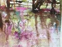 Riverbank Reflections Distant trees with lavender flowers reflected in the river below.