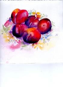 Five brightly coloured plums on a flower decorated plate